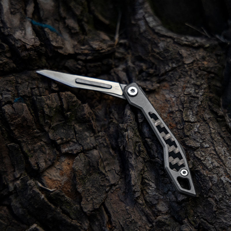 WaspArmor Blade titanium micro folding scalpel knife on a black rock background