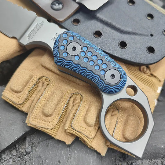 Close-up of a claw forge tactical edc knife with a blue handle and metal blade on beige fabric