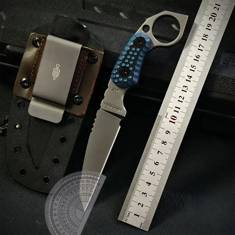 Claw forge tactical edc knife with blue handle next to a ruler on a dark surface